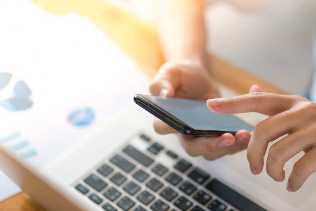 Una scrivania con grafici finanziari, telefono e computer